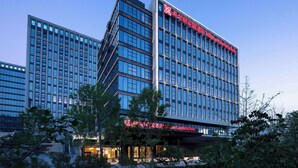 Un hôtel moderne, avec de nombreux étages et de grandes fenêtres.