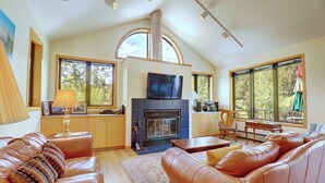 A spacious living room with leather sofas, a fireplace, and large windows offering views of the outdoors. - Beautiful Views, Awesome Amenities, 195 Eastridge (Dillon)