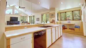 A modern kitchen with a dishwasher, a sink, and a dining area with a table and chairs. - Beautiful Views, Awesome Amenities, 195 Eastridge (Dillon)