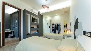 Un dormitorio moderno con dos camas, un televisor y un armario.