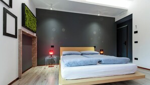 A modern bedroom with a floating bed, a green wall feature, and a clear nightstand.