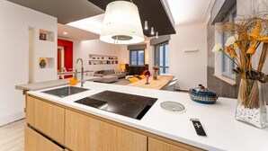 A modern kitchen with a central island, built-in oven, and a pendant light. - Camere CA + Millo - Camera 3 (Crevacuore)