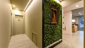 A hallway with a green wall feature, a framed picture, and a wooden floor. - Camere CA + Millo - Camera 3 (Crevacuore)