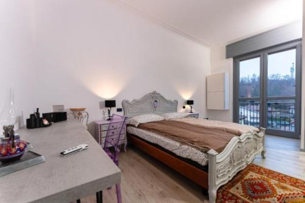 Une chambre à coucher avec un lit, des tables de chevet, un bureau et une chaise.