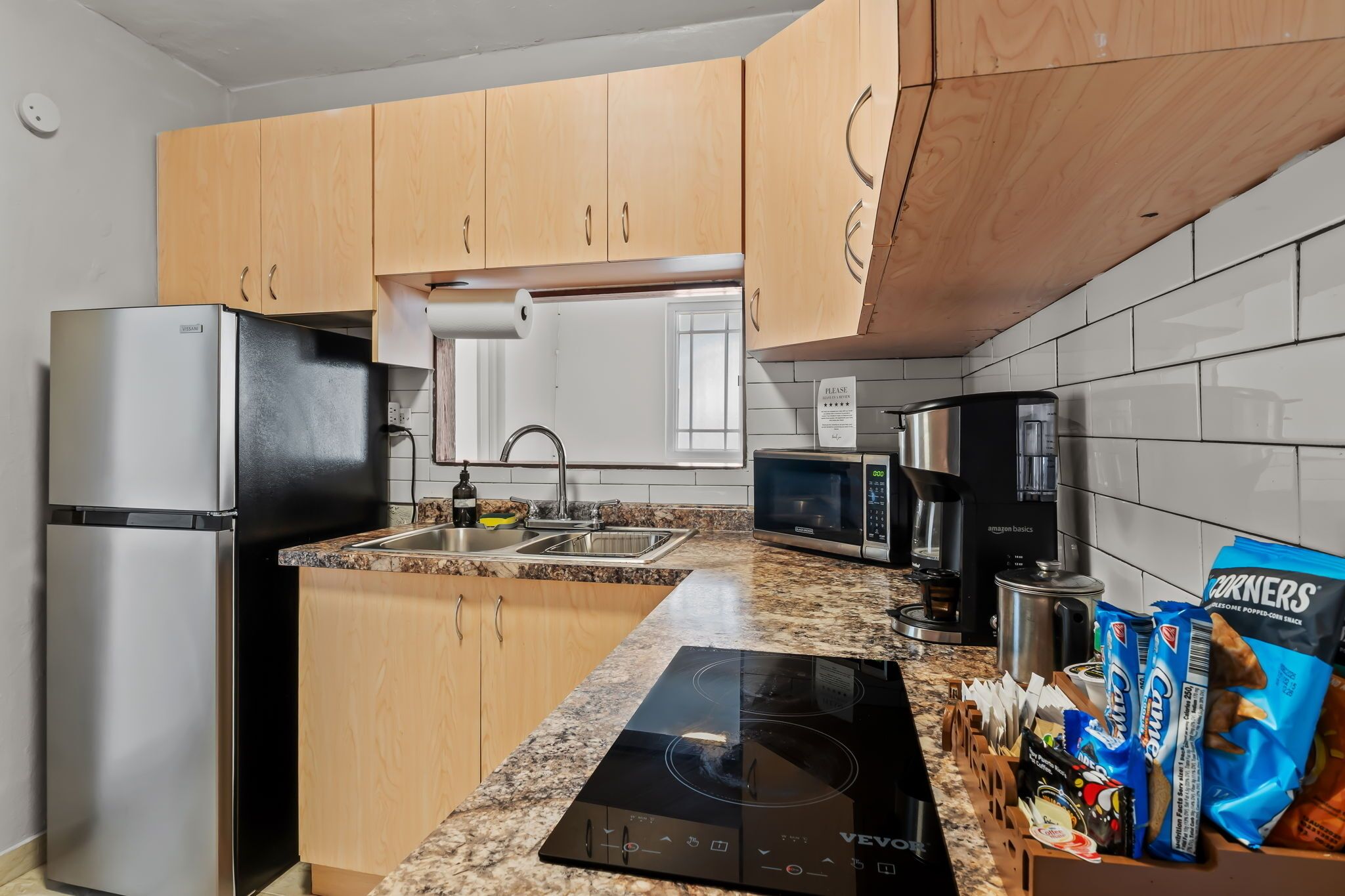 A kitchen with wooden cabinets, stainless steel appliances, a granite countertop, and a built-in stove.