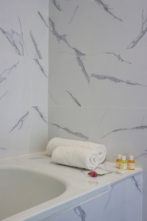 Bathtub, hair dryer, slippers, towels