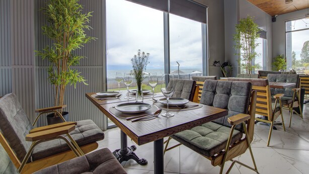 Een moderne eetruimte met een houten tafel gedekt voor vier personen, omringd door beklede stoelen.