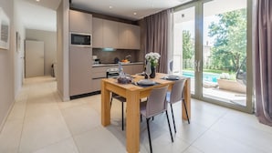 Een moderne keuken met een eethoek, uitzicht op het buitenleven en een schuifdeur.