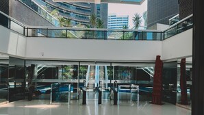 A spacious atrium with a central escalator, glass railings, and modern architecture. - Landscape Torre Platinum (Fortaleza)