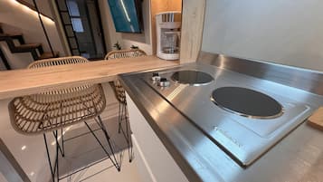 Cafetera o tetera, frigorífico, microondas y placa de cocina
