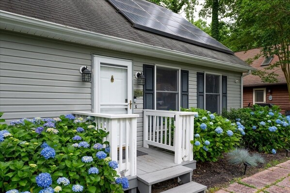 A house with a white front door, a small porch with white railings, and a solar panel on the roof. - Dream Cottage in Lewes (Lewes)