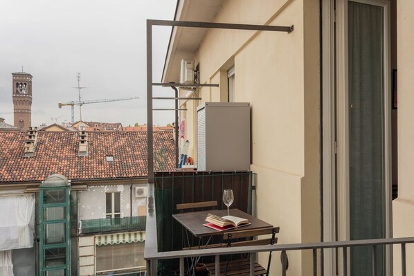 A balcony with a table, a book, and a wine glass. - Sui Tetti di Torino by Wonderful Italy (Turin)