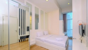 Ein modernes Schlafzimmer mit einem großen Bett, einem Kleiderschrank und einem Spiegel.