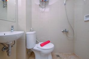Un baño con lavamanos, inodoro y ducha.