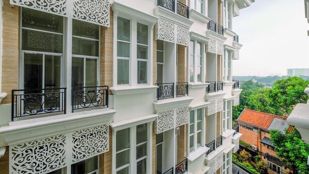 Un immeuble à plusieurs étages, doté de balcons décorés et de grandes fenêtres.