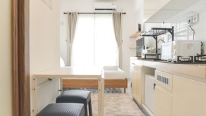 Eine kleine Küchenzeile mit Bett, Tisch und Bank.