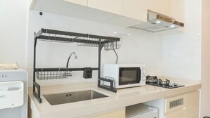 Eine moderne Küche mit integriertem Mikrowellenherd, Spüle und Geschirrtrockner.