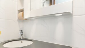 Ein Badezimmer mit Waschbecken, Spiegel und Toilettenpapier.