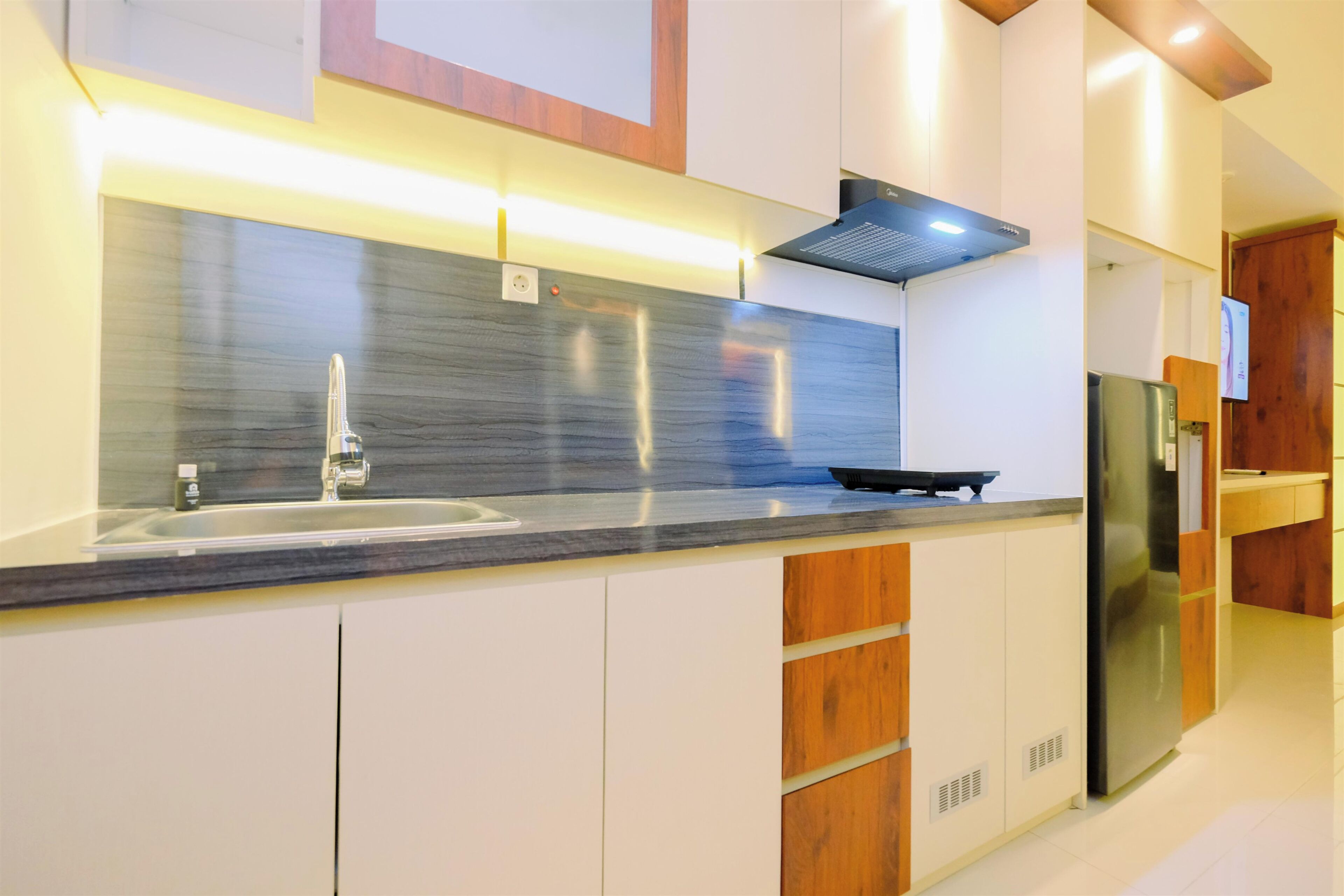 Una cocina moderna con un refrigerador de acero inoxidable, un horno integrado y una encimera elegante.