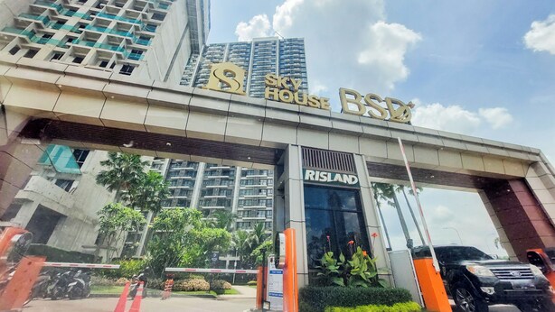 A hotel entrance with a large sign reading "Sky House B&Q" and "RISLAND" above the door. - Good Designed And Restful Studio Sky House Bsd Apartment (Pagedangan)