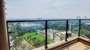 A high-rise building with a glass balcony overlooking a cityscape. - Good Designed And Restful Studio Sky House Bsd Apartment (Pagedangan)