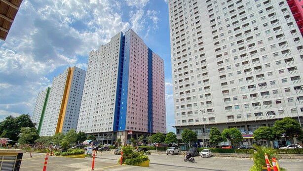 A multi-story building with a modern architectural design, featuring a prominent vertical color stripe on one of the buildings.
