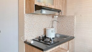 A compact kitchen with a built-in microwave, a small sink, and a stovetop.