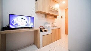 A small kitchenette with a television, a coffee maker, and a portable heater. - Strategic And Homey 1Br At The City Square Apartment (Surabaya)