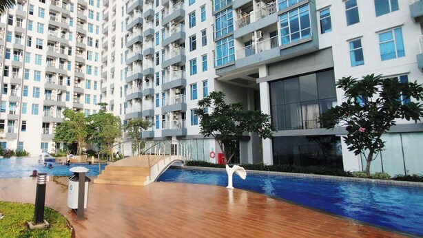 A residential building with multiple balconies, a swimming pool, and a covered outdoor area. - Simple And Modern Studio (No Kitchen) Anderson Supermall Mansion Apartment (Surabaya)