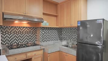 Departamento Deluxe | Cocina privada | Refrigerador con congelador, microondas, parrilla de estufa y comedor