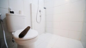 A bathroom with a white toilet, a shower, and a toilet paper holder. - Best Location And Restful 1Br At The City Square Apartment (Surabaya)