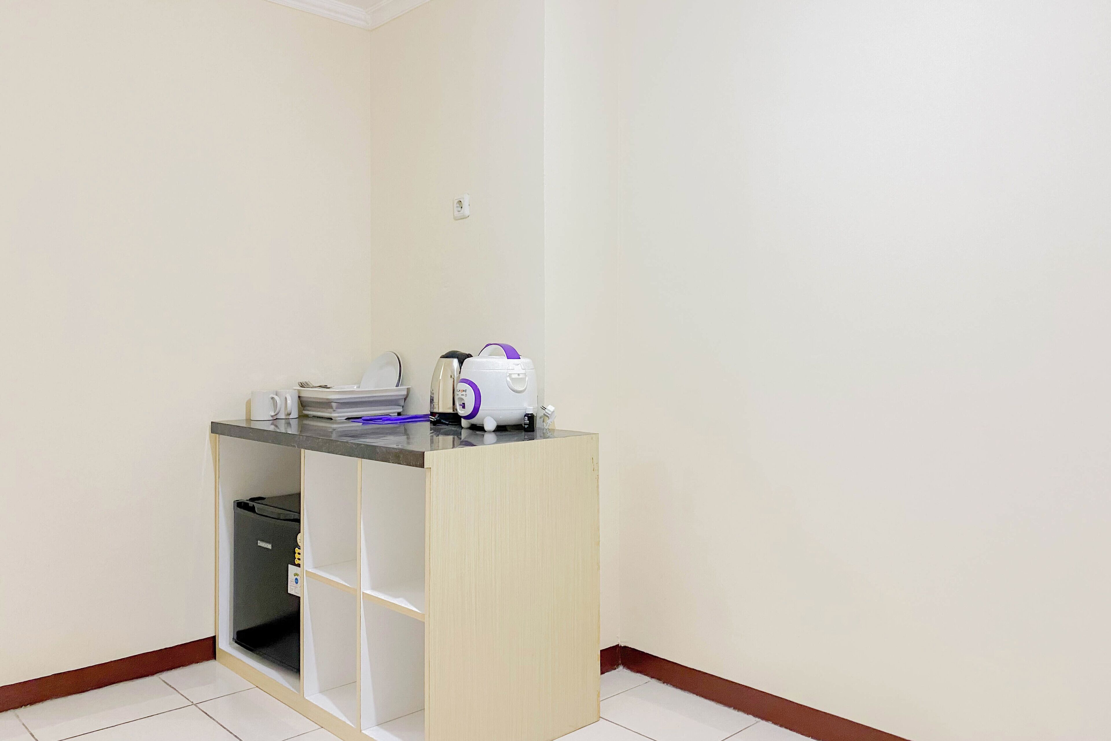 A small kitchenette with a microwave, toaster, and coffee maker on a counter.