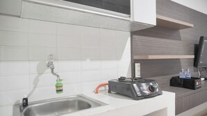 A modern kitchen with a stainless steel sink, a built-in toaster, and a water dispenser. - Cozy Living Studio At Green Bay Pluit Apartment (Jakarta)