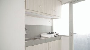 A kitchen with light wood cabinets, a stainless steel sink, and a window with a view.