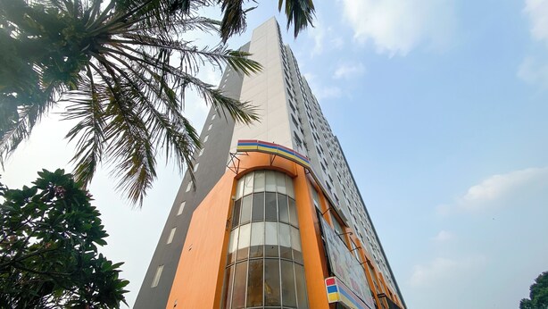 A tall building with a curved orange facade and large windows.