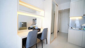 A hotel room with a dining area, a kitchenette, and a large mirror. - Nice And Modern Studio At Benson Supermall Mansion Apartment (Surabaya)
