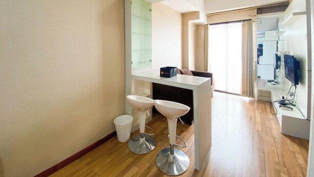A modern bathroom with a white vanity, a large mirror, and a glass shower enclosure. - Signature 2Br At Apartment Tamansari Panoramic (Bandung)