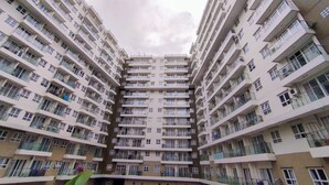 A high-rise residential building with multiple balconies and air conditioning units. - Amazing 1Br Apartment Gateway Pasteur (Cimahi)
