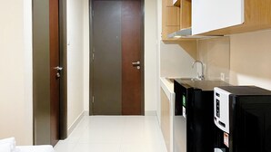 A modern kitchen with a refrigerator, sink, and wooden cabinets.