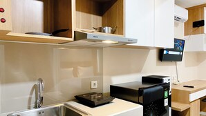 A modern kitchen with a stainless steel sink, a black dishwasher, and a wooden countertop.