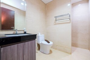 Une salle de bain moderne avec un lavabo noir, des toilettes blanches et un porte-serviettes fixé au mur.