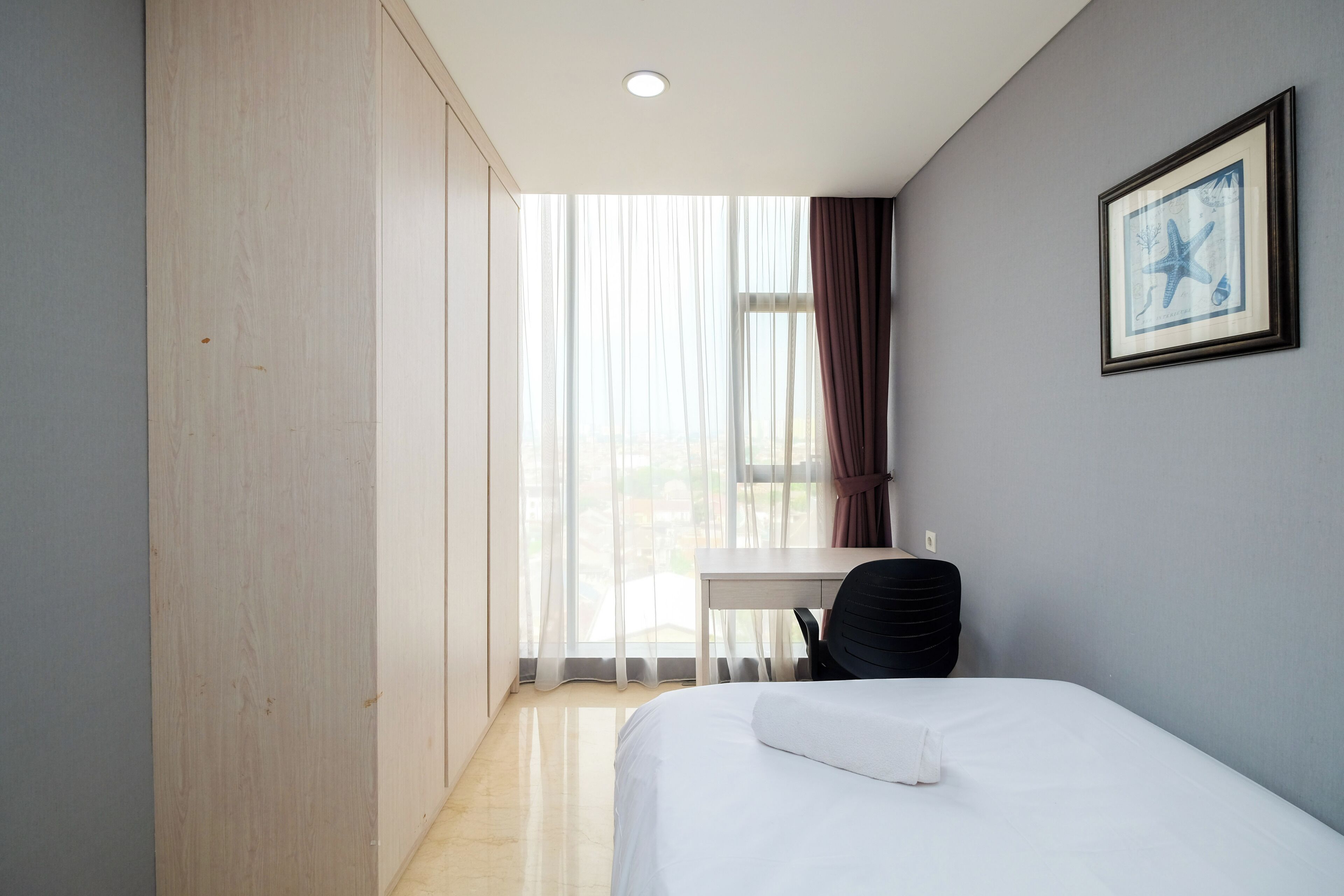 Ein Hotelzimmer mit Bett, Schreibtisch und Stuhl.