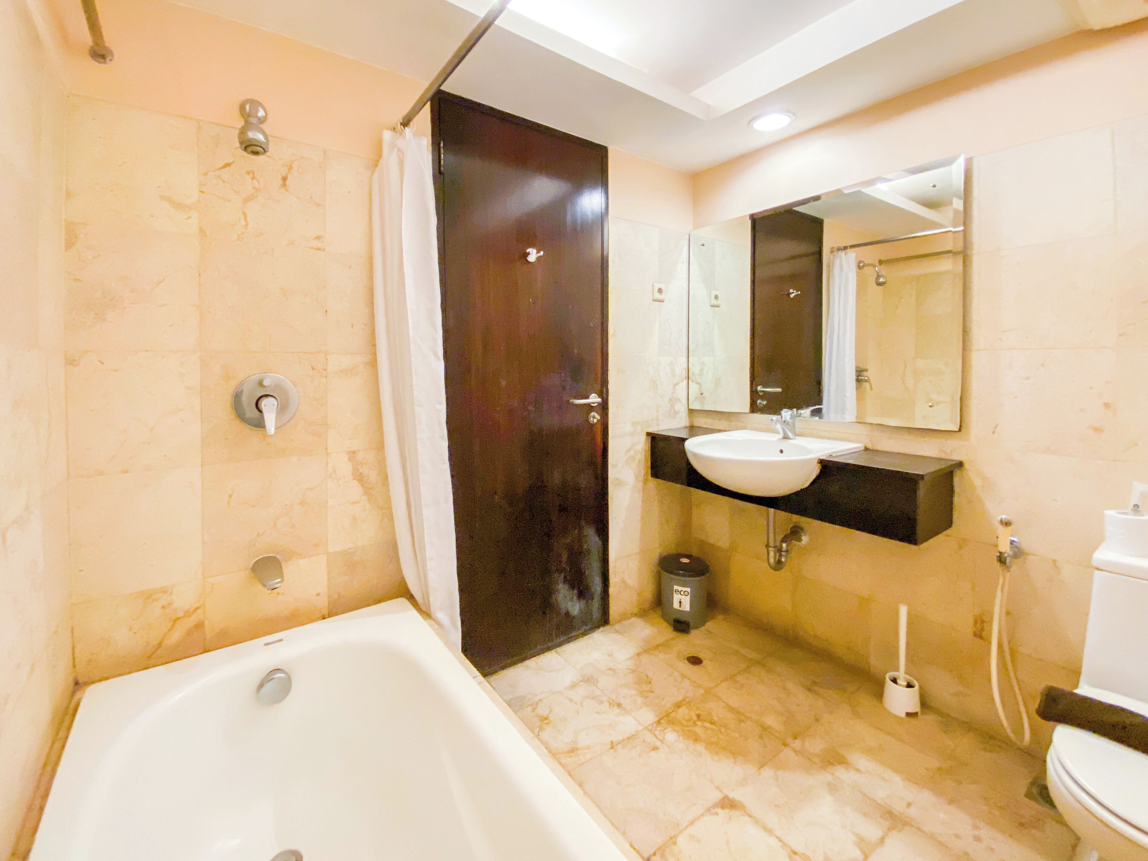 A bathroom with a bathtub, a sink, a toilet, and a shower curtain.