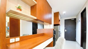 Una cocina moderna con armarios de madera, encimera blanca y una silla blanca integrada.