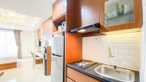Una cocina moderna con armarios de madera, un lavamanos de acero inoxidable y un horno empotrado.