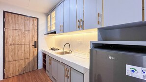 Una cucina moderna con frigorifero in acciaio inox, lavello e pensili in legno.