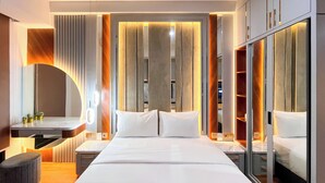 Una moderna camera d'albergo con un letto grande, comodini, una toeletta con specchio e un armadio con specchio.