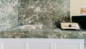 A kitchen with a marble countertop, a sink, and a toaster. - Good Deal And Homey Studio At Royal Sentul Park Apartment (Bogor)
