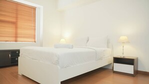 A bedroom with a bed, bedside tables, and a window with blinds. - Good Place 2Br Apartment At Sudirman Tower Condominium (Jakarta)
