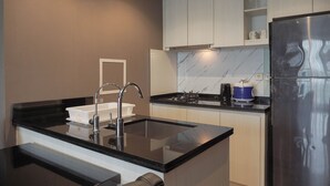 Eine moderne Küche mit schwarzem Arbeitsplatz, Edelstahlgeräten und weißen Schränken.
